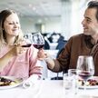 Spisende par på restaurant med vin